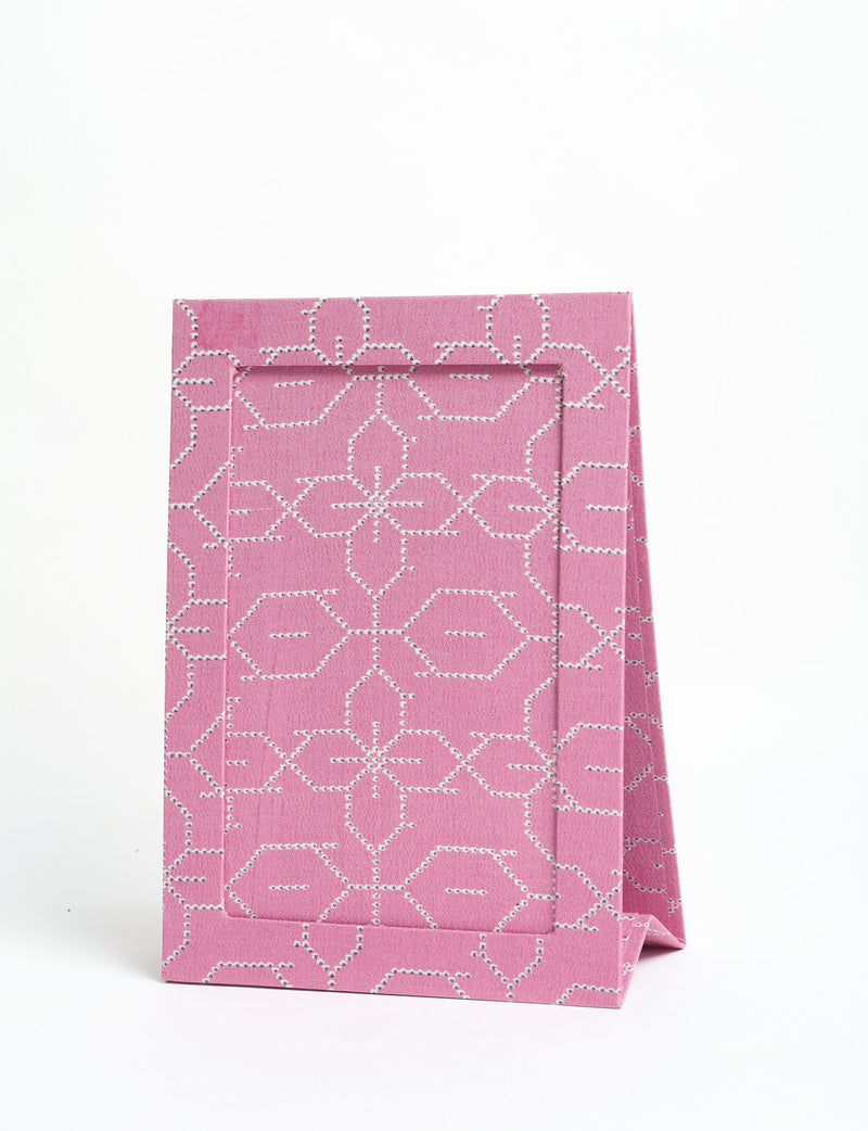 Pink geometric patterned fabric photo frame standing upright with an A5 size display window on a white background