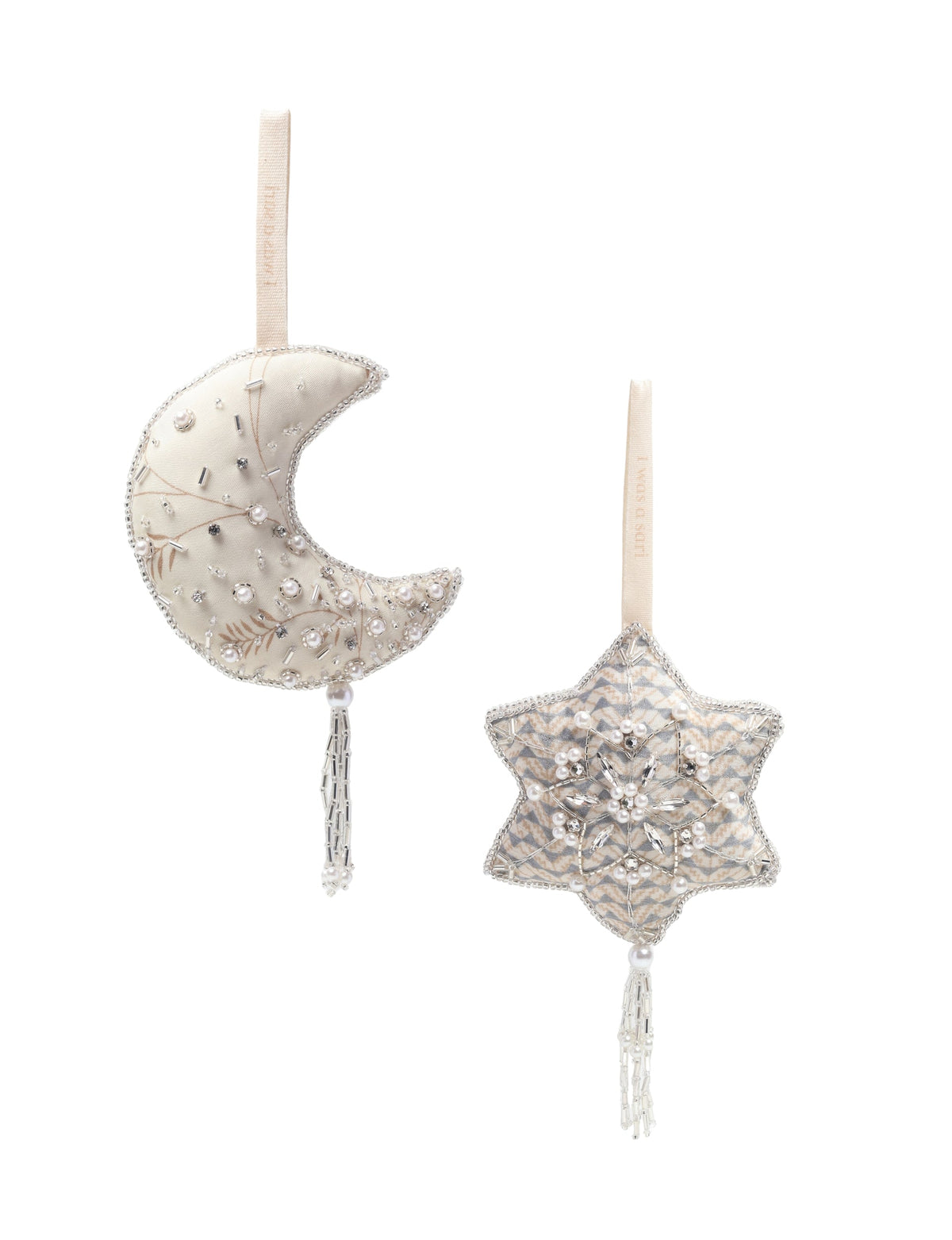 Set of two cream fabric ornaments, one crescent moon and one star, decorated with beads, pearls, and hanging tassels