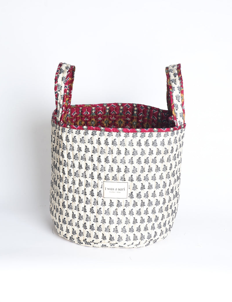Quilted storage basket with handle in a soft cylindrical design, available in small and medium sizes for home organization.