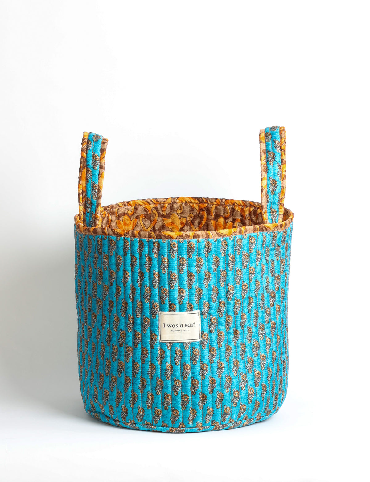 Quilted storage basket with handle in a soft cylindrical design, available in small and medium sizes for home organization.