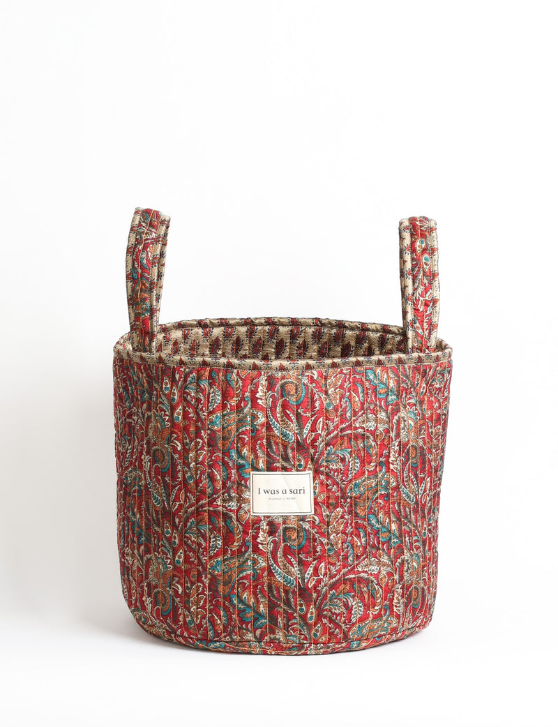 Quilted storage basket with handle in a soft cylindrical design, available in small and medium sizes for home organization.