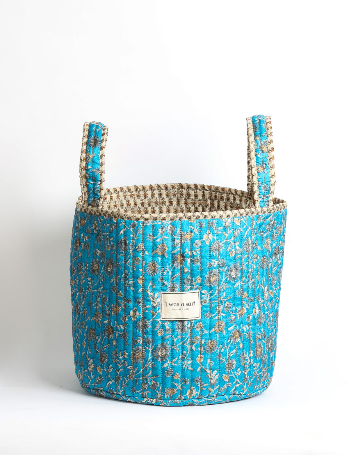 Quilted storage basket with handle in a soft cylindrical design, available in small and medium sizes for home organization.