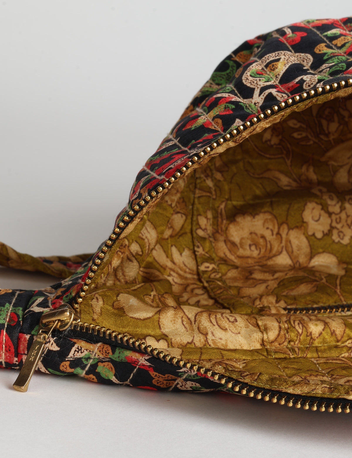 Quilted large shoulder bag with a curved silhouette, adjustable strap and zip-top closure.