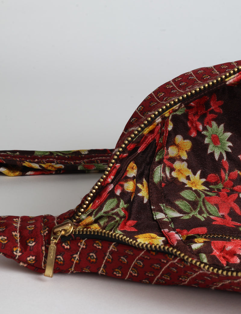 Quilted large shoulder bag with a curved silhouette, adjustable strap and zip-top closure.