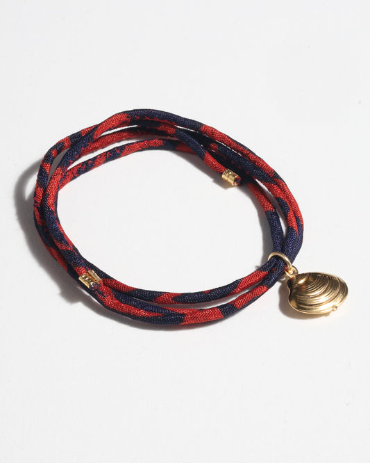 Adjustable slim cord bracelet with gold-plated stainless steel shell charm inspired by upcycled women’s clothing, sustainable women’s clothing, eco friendly clothes, recycled sustainable fashion, carbon neutral clothing, and environment friendly clothing values.