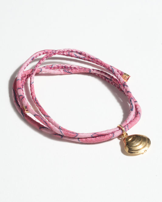 Adjustable slim cord bracelet with gold-plated stainless steel shell charm inspired by upcycled women’s clothing, sustainable women’s clothing, eco friendly clothes, recycled sustainable fashion, carbon neutral clothing, and environment friendly clothing values.