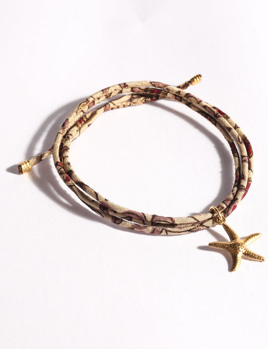 Slim adjustable cord bracelet with gold-plated stainless steel star fish charm inspired by upcycled women’s clothing, sustainable women’s clothing, eco friendly clothes, recycled sustainable fashion, carbon neutral clothing, and environment friendly clothing values.