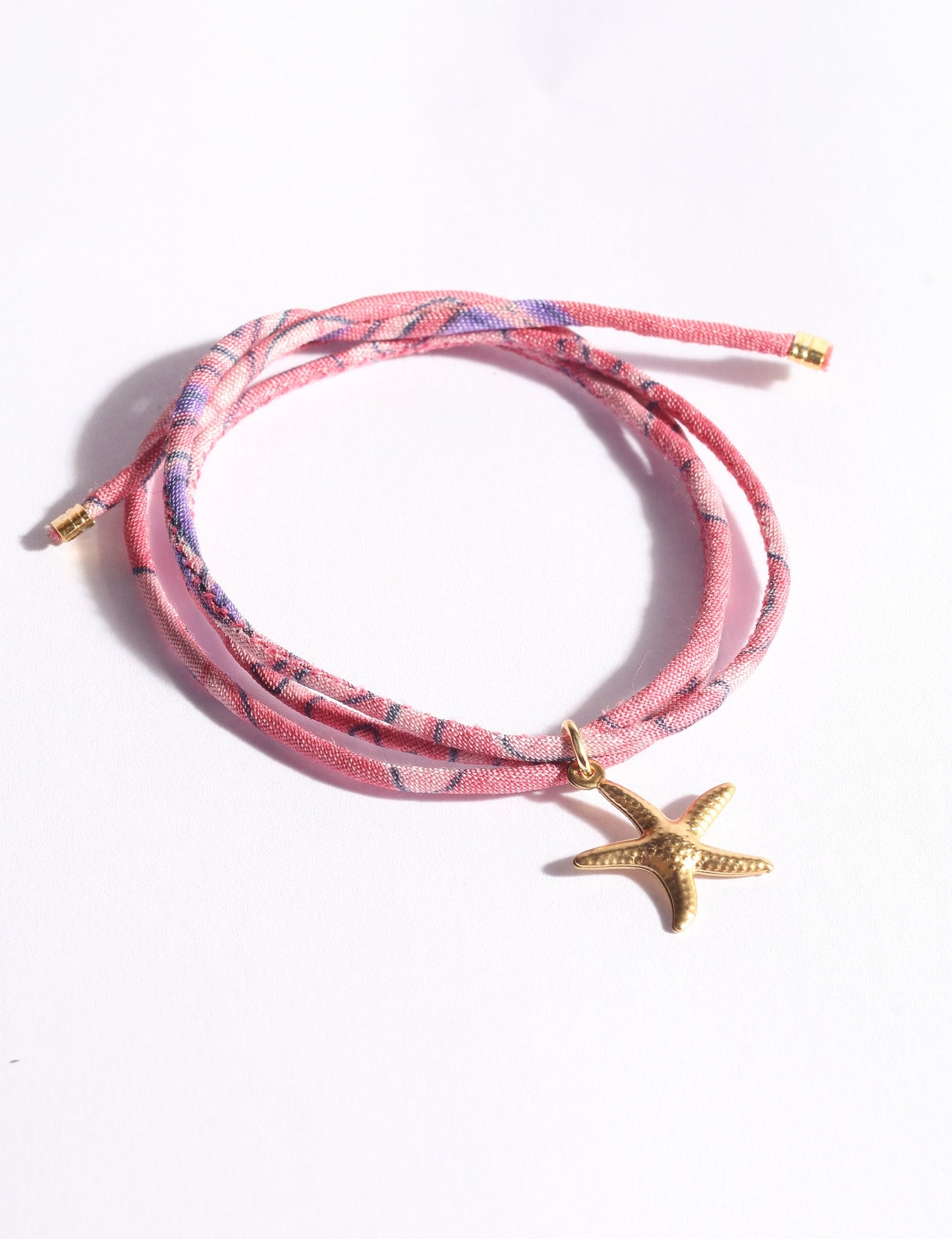 Slim adjustable cord bracelet with gold-plated stainless steel star fish charm inspired by upcycled women’s clothing, sustainable women’s clothing, eco friendly clothes, recycled sustainable fashion, carbon neutral clothing, and environment friendly clothing values.