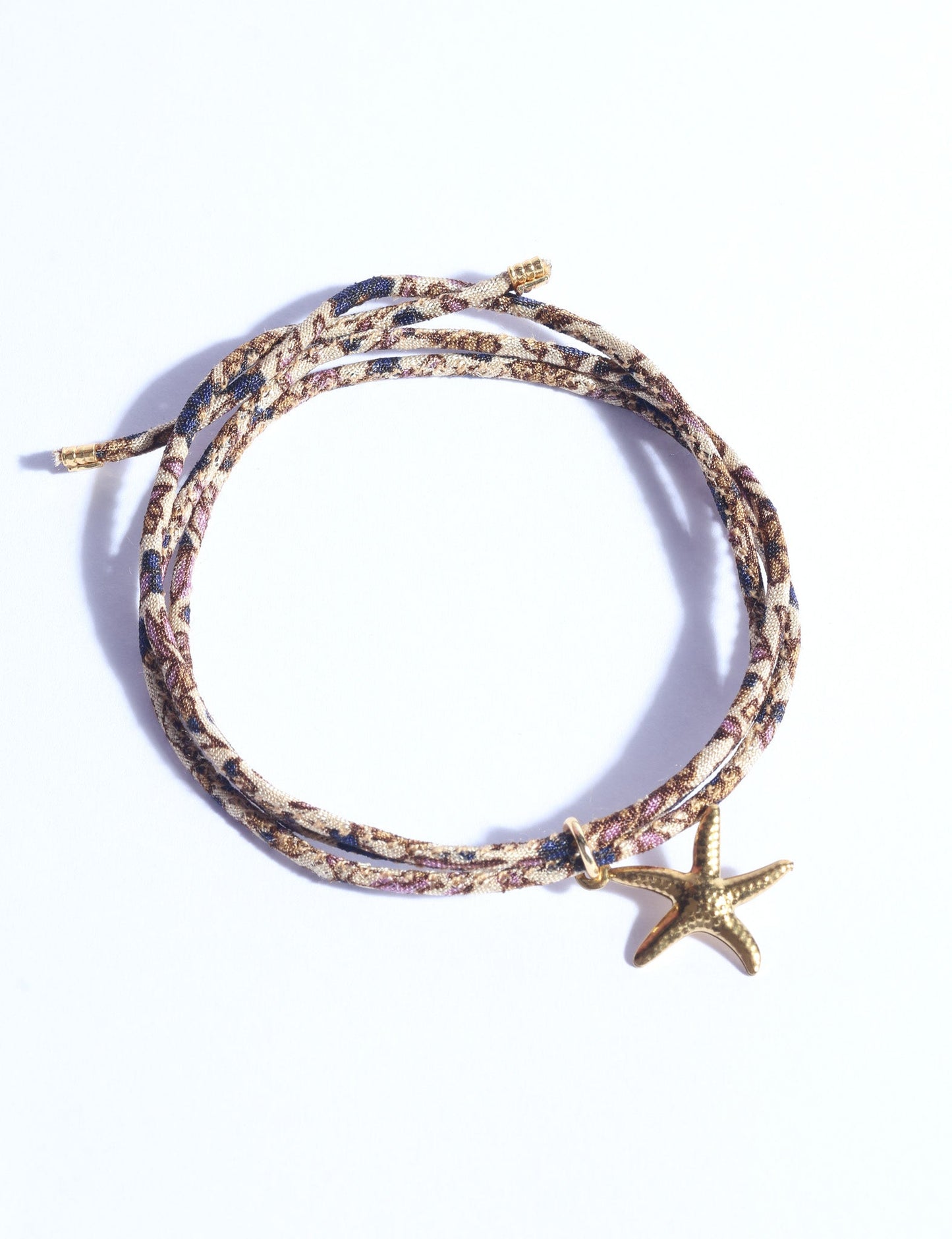 Slim adjustable cord bracelet with gold-plated stainless steel star fish charm inspired by upcycled women’s clothing, sustainable women’s clothing, eco friendly clothes, recycled sustainable fashion, carbon neutral clothing, and environment friendly clothing values.