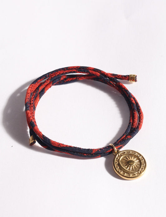 Slim adjustable cord bracelet with gold-plated stainless steel sun charm, inspired by upcycled women’s clothing, sustainable women’s clothing, eco friendly fashion, recycled sustainable fashion, carbon neutral fashion, and environment friendly clothing values.