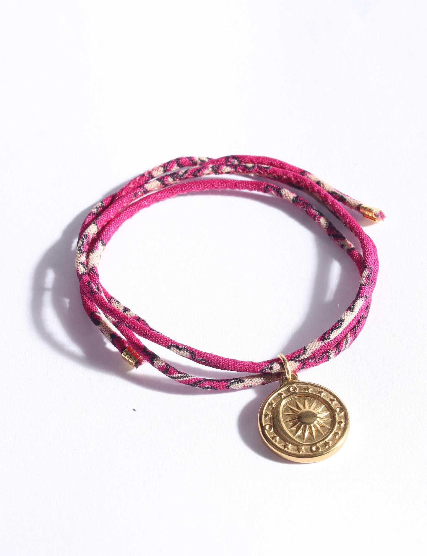 Slim adjustable cord bracelet with gold-plated stainless steel sun charm, inspired by upcycled women’s clothing, sustainable women’s clothing, eco friendly fashion, recycled sustainable fashion, carbon neutral fashion, and environment friendly clothing values.