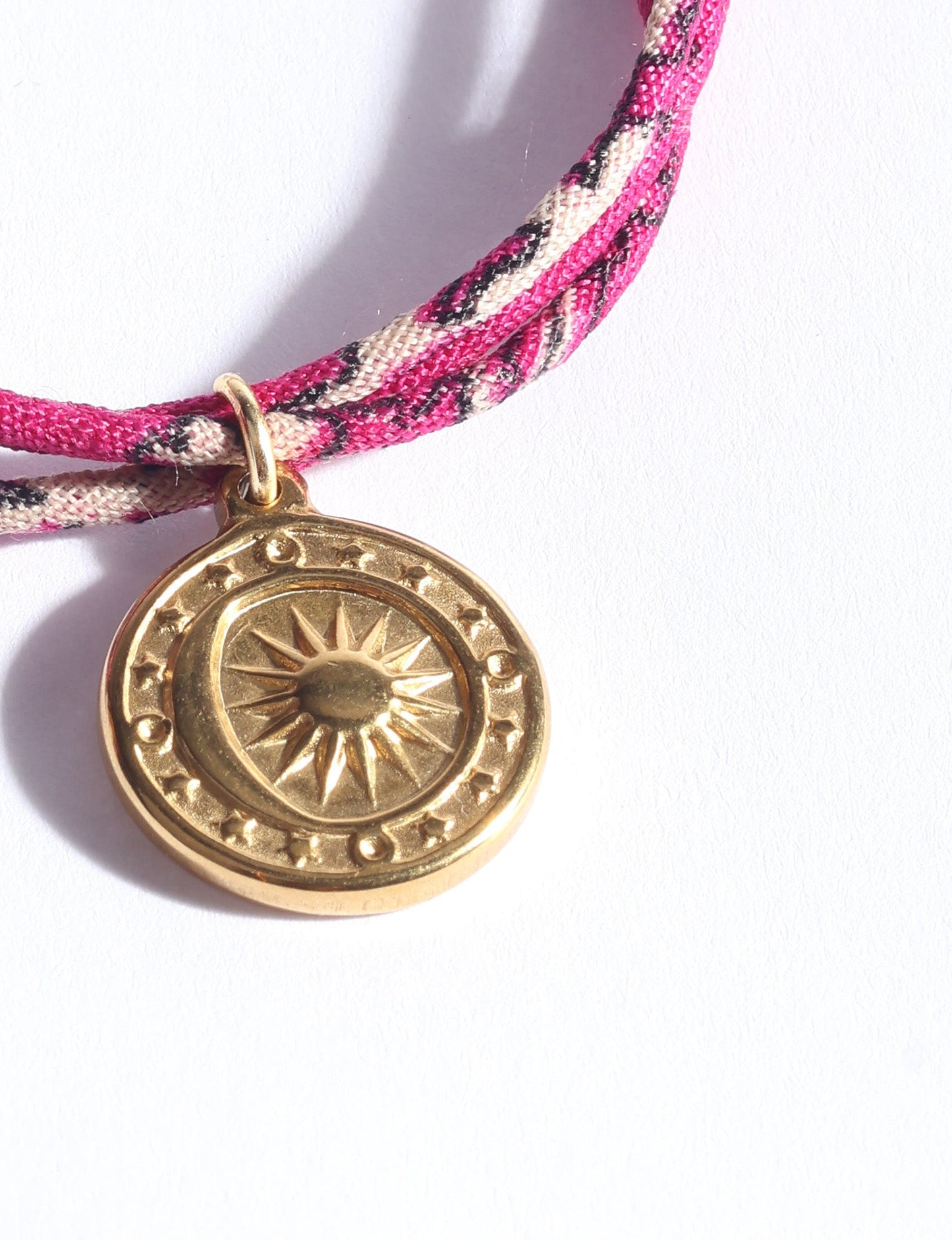 Slim adjustable cord bracelet with gold-plated stainless steel sun charm, inspired by upcycled women’s clothing, sustainable women’s clothing, eco friendly fashion, recycled sustainable fashion, carbon neutral fashion, and environment friendly clothing values.