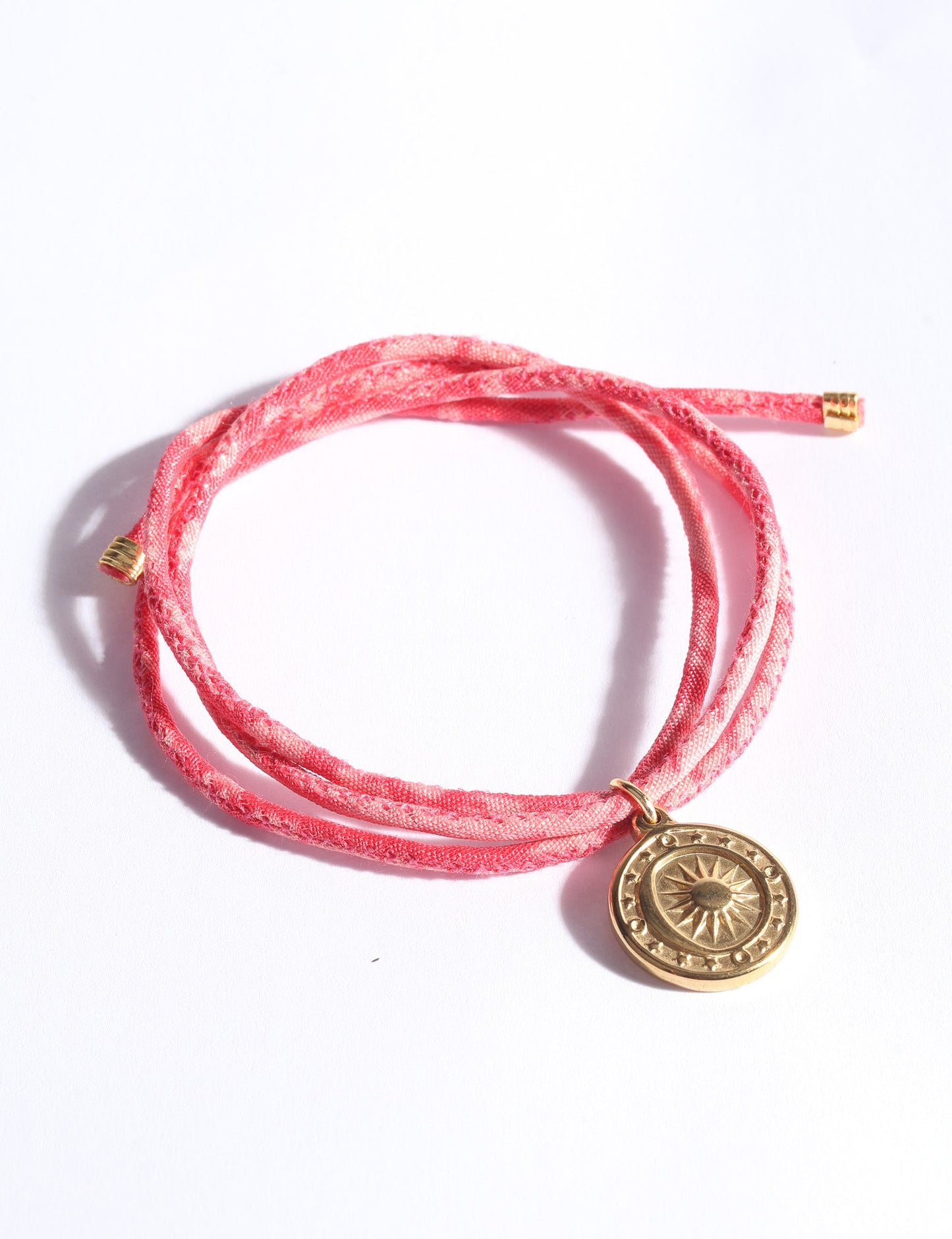 Slim adjustable cord bracelet with gold-plated stainless steel sun charm, inspired by upcycled women’s clothing, sustainable women’s clothing, eco friendly fashion, recycled sustainable fashion, carbon neutral fashion, and environment friendly clothing values.