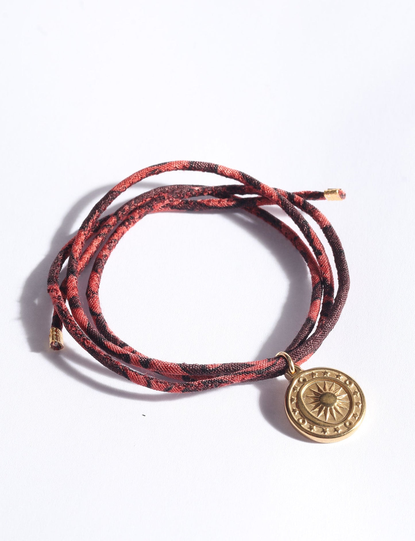Slim adjustable cord bracelet with gold-plated stainless steel sun charm, inspired by upcycled women’s clothing, sustainable women’s clothing, eco friendly fashion, recycled sustainable fashion, carbon neutral fashion, and environment friendly clothing values.