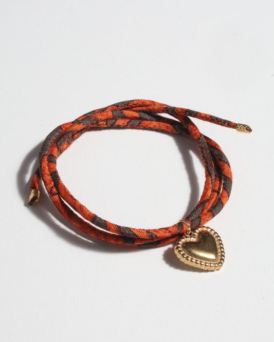 Slim adjustable cord bracelet with gold-plated stainless steel heart charm inspired by upcycled women’s clothing, sustainable women’s clothing, eco friendly fashion, recycled sustainable fashion, carbon neutral fashion, and environment friendly clothes values.