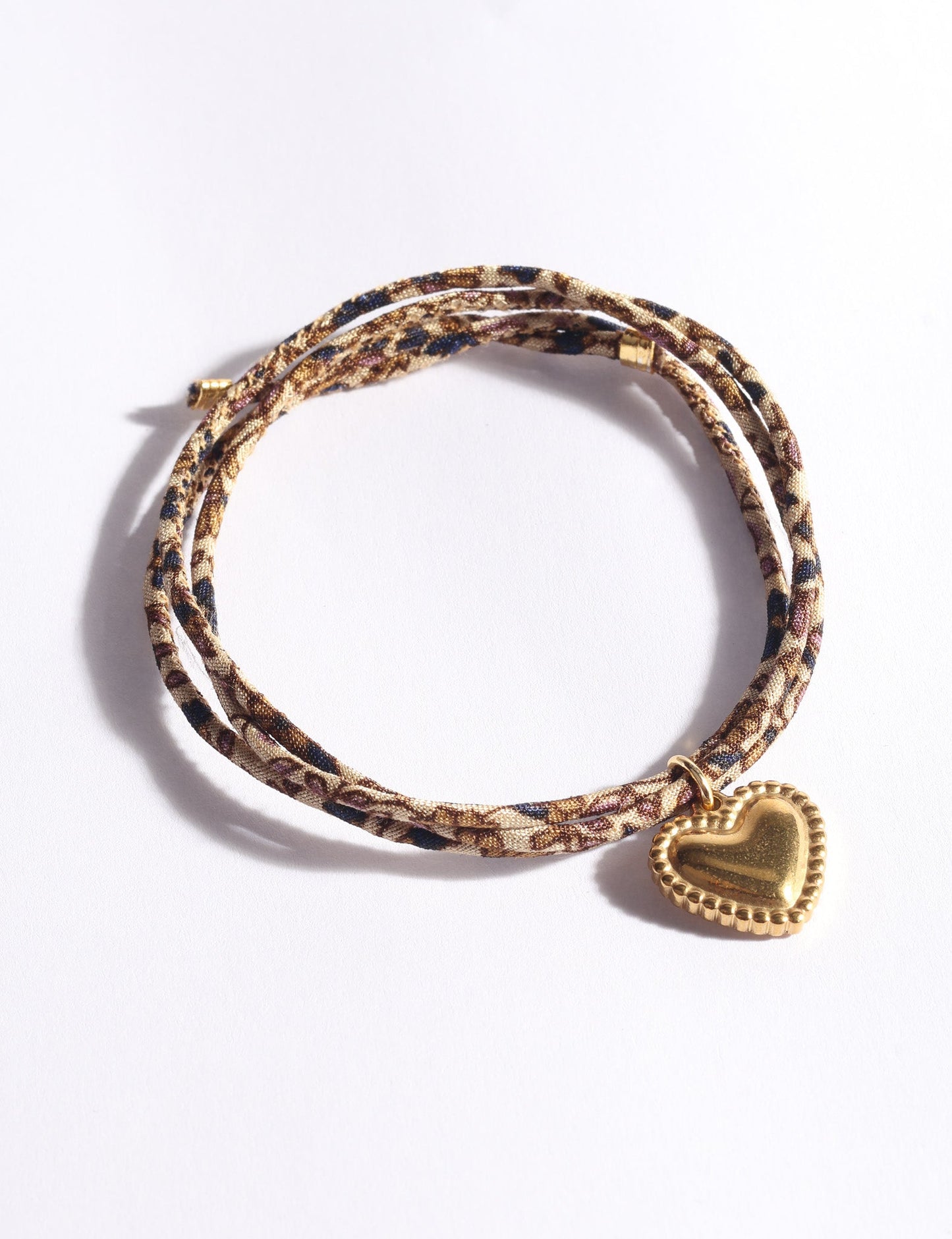 Slim adjustable cord bracelet with gold-plated stainless steel heart charm inspired by upcycled women’s clothing, sustainable women’s clothing, eco friendly fashion, recycled sustainable fashion, carbon neutral fashion, and environment friendly clothes values.