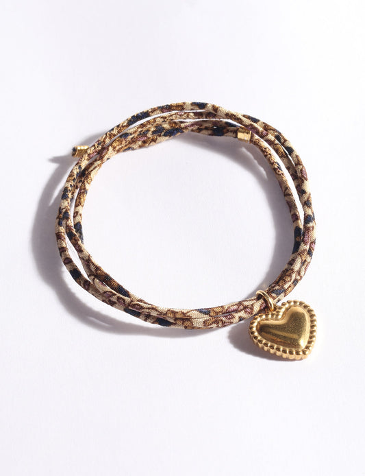 Slim adjustable cord bracelet with gold-plated stainless steel heart charm inspired by upcycled women’s clothing, sustainable women’s clothing, eco friendly fashion, recycled sustainable fashion, carbon neutral fashion, and environment friendly clothes values.
