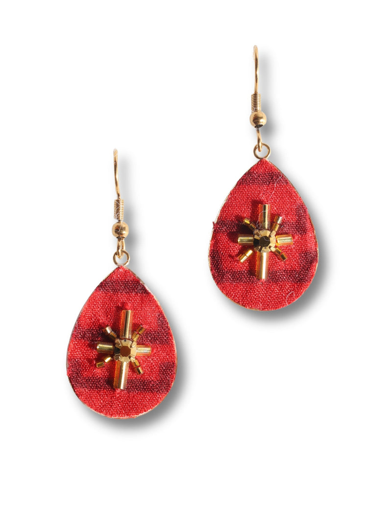 Red teardrop-shaped fabric earrings with gold-tone beaded cross embellishment and gold hooks, shown flat on white background