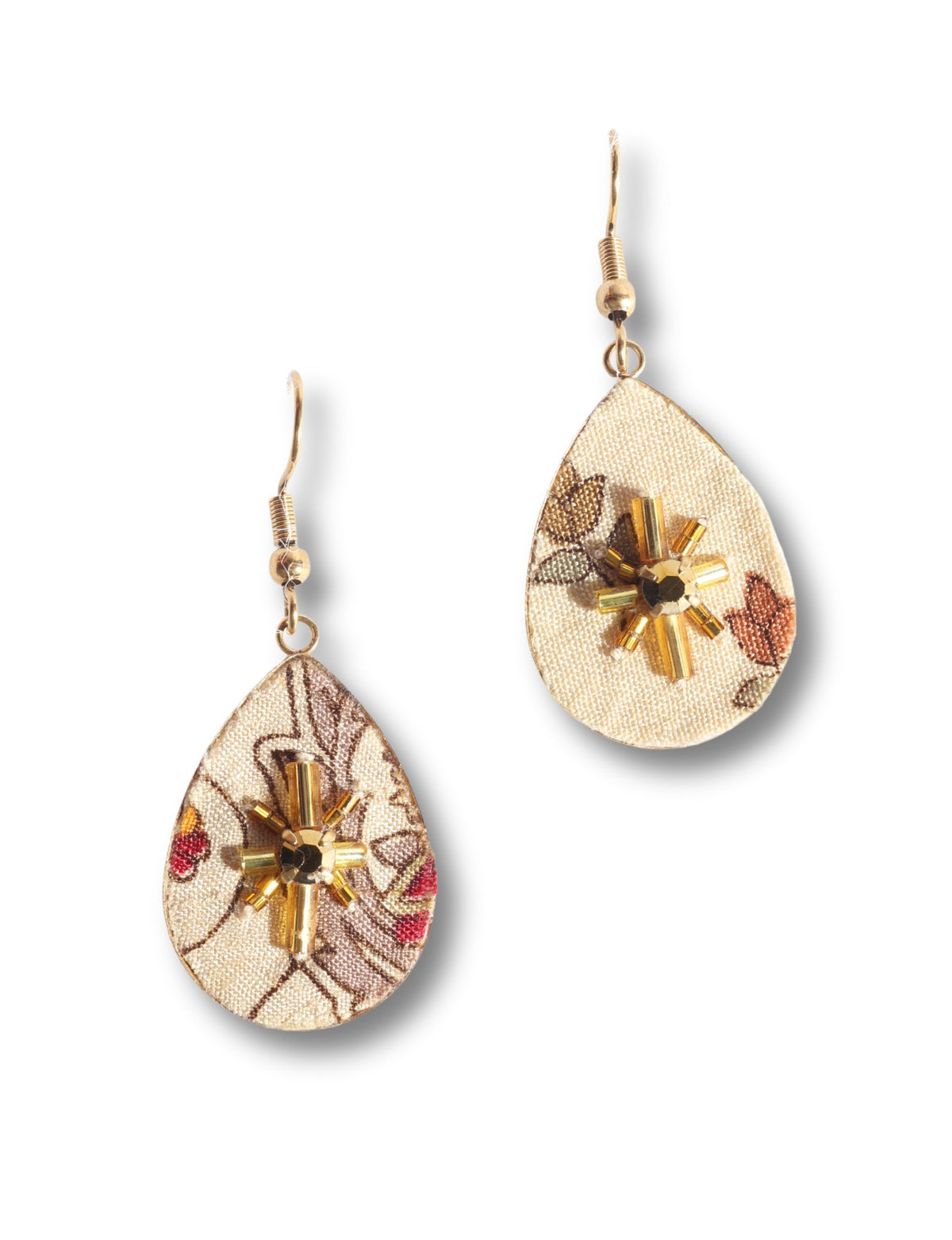 Beige teardrop earrings with tropical floral print fabric and gold bead sunburst embellishments, shown flat on white background