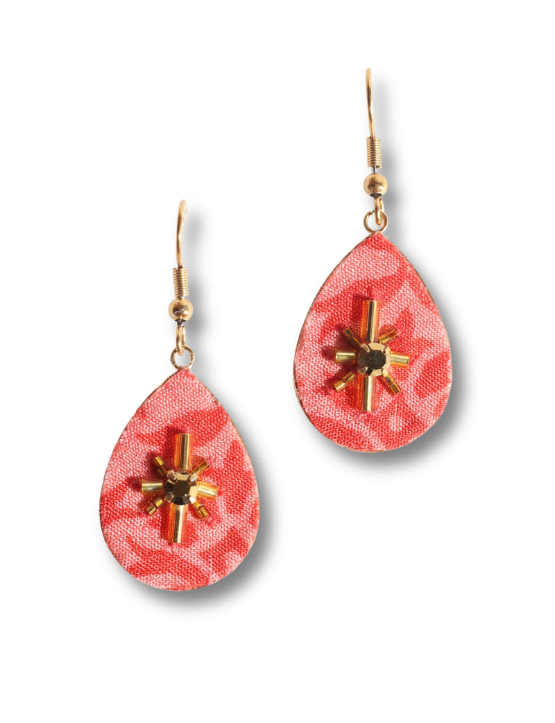 Pink fabric teardrop earrings with gold-tone bead and tube embellishments, shown in close-up front view