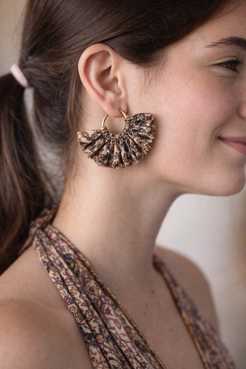 Beige tropical frill fabric hoop earrings worn by model with matching patterned halter top, side view close-up