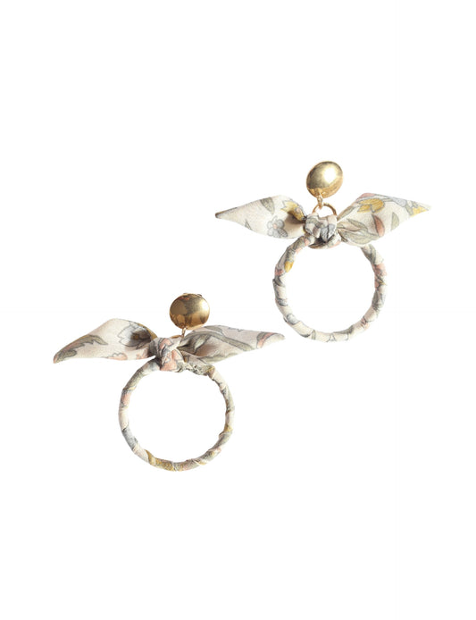 Drop earrings with bow detail and circular ring inspired by upcycled women’s clothing, sustainable women’s clothing, eco friendly clothes, recycled sustainable fashion, carbon neutral clothing, and environment friendly clothing values.