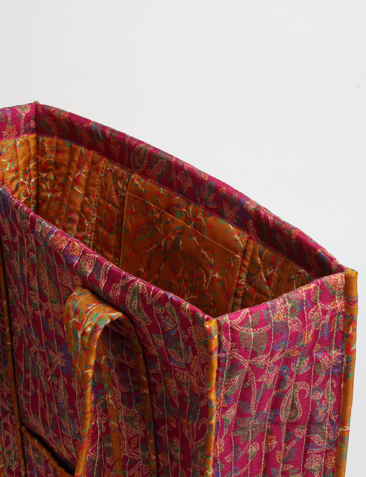Quilted carry-all tote bag with long shoulder straps, flat base, and external patch pocket.