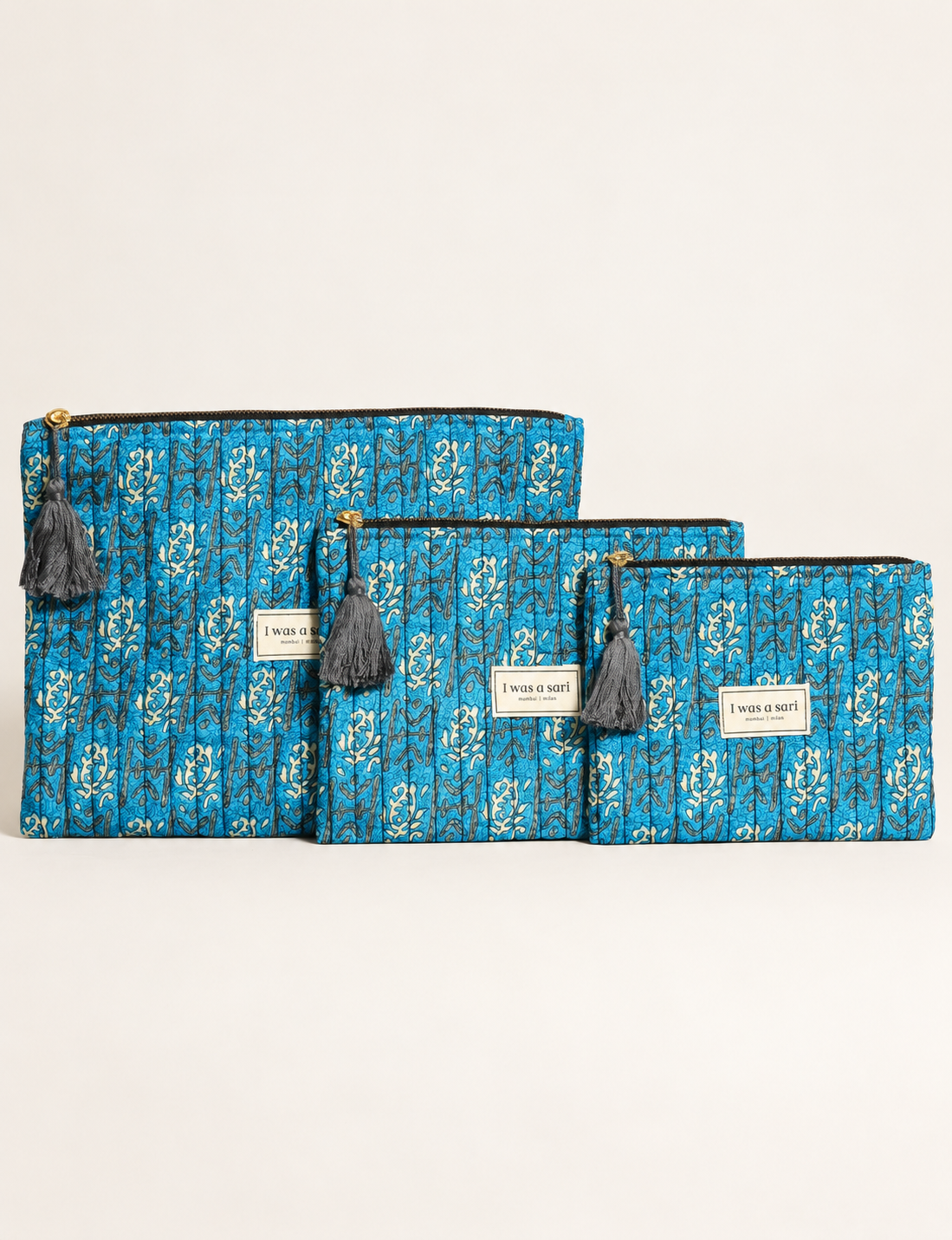 Quilted zipper pouch with tassel trim, available in three sizes for organising everyday essentials.