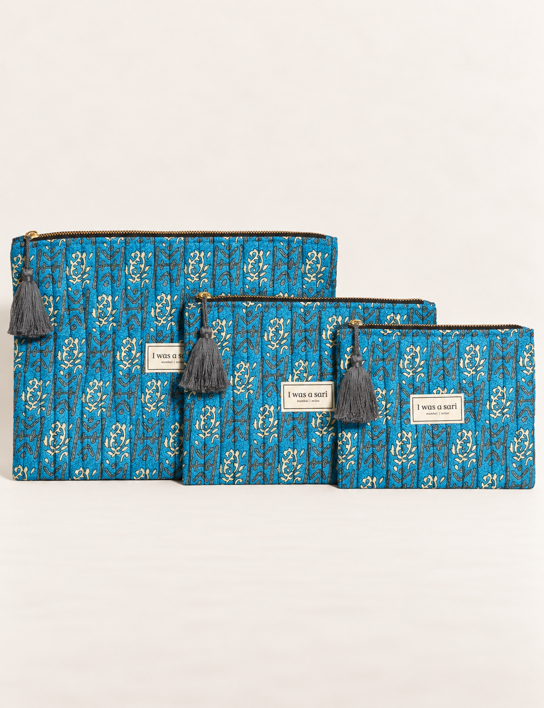 Quilted zipper pouch with tassel trim, available in three sizes for organising everyday essentials.