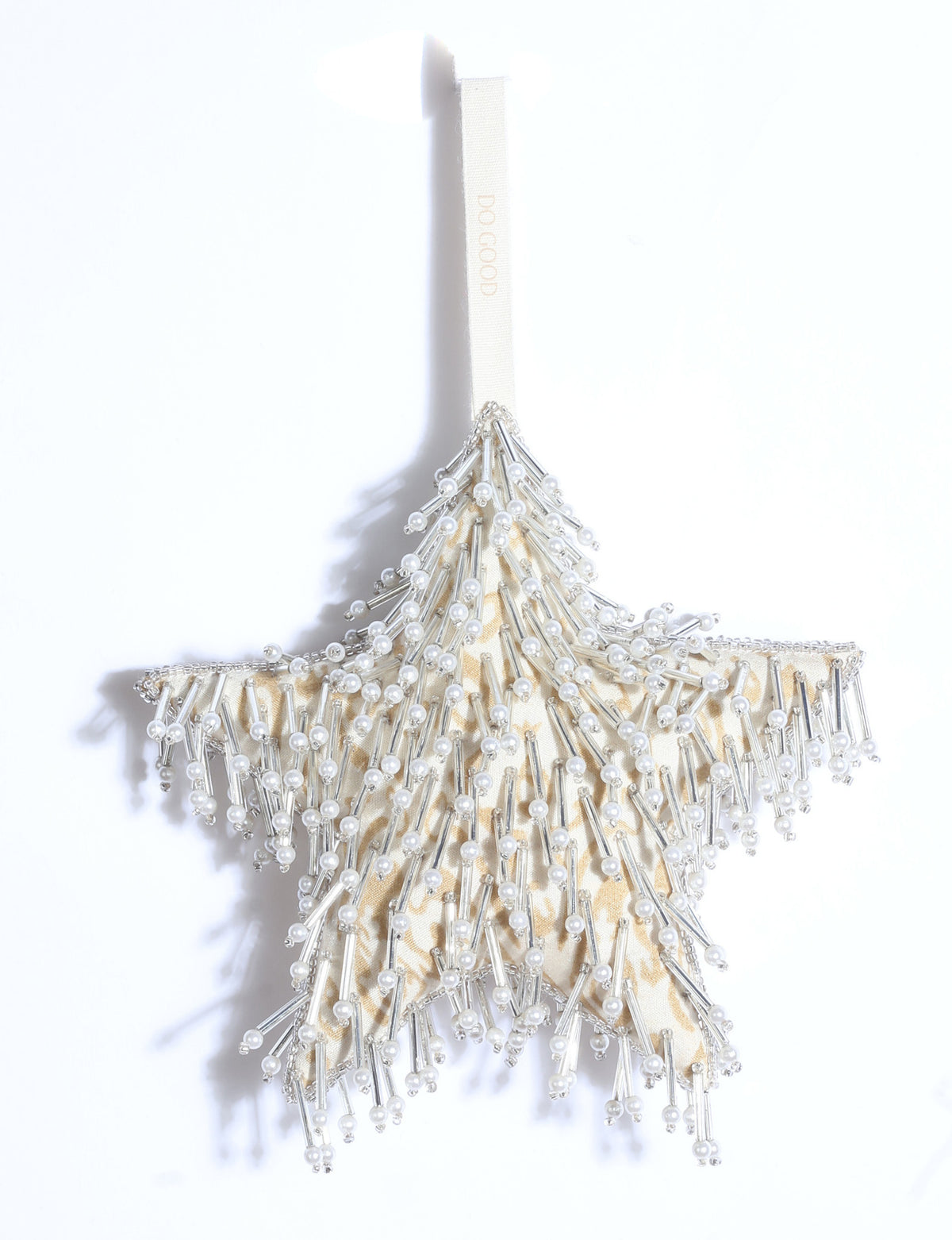 Silver star Christmas ornament made from upcycled ivory and grey saris with silver embroidery, pearls, sequins, and beads.