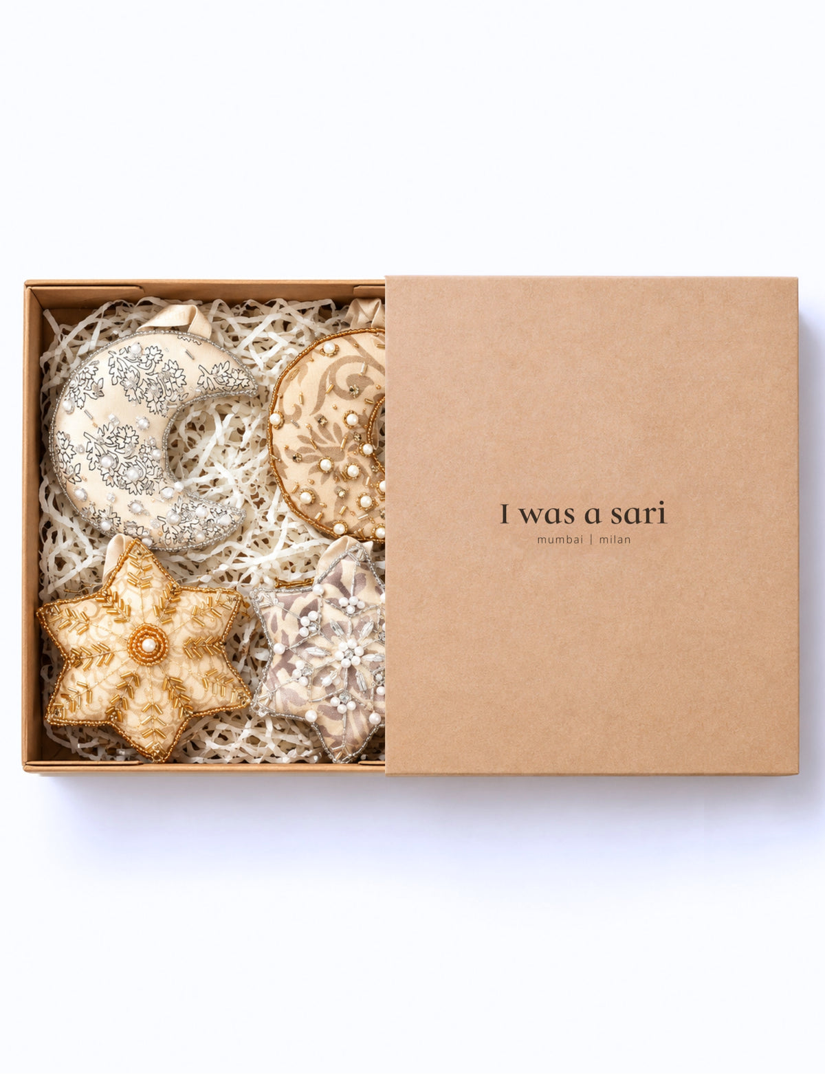 Handcrafted ivory and grey upcycled sari Christmas ornaments in moon and star shapes with gold and silver embroidery, beads, and pearls.