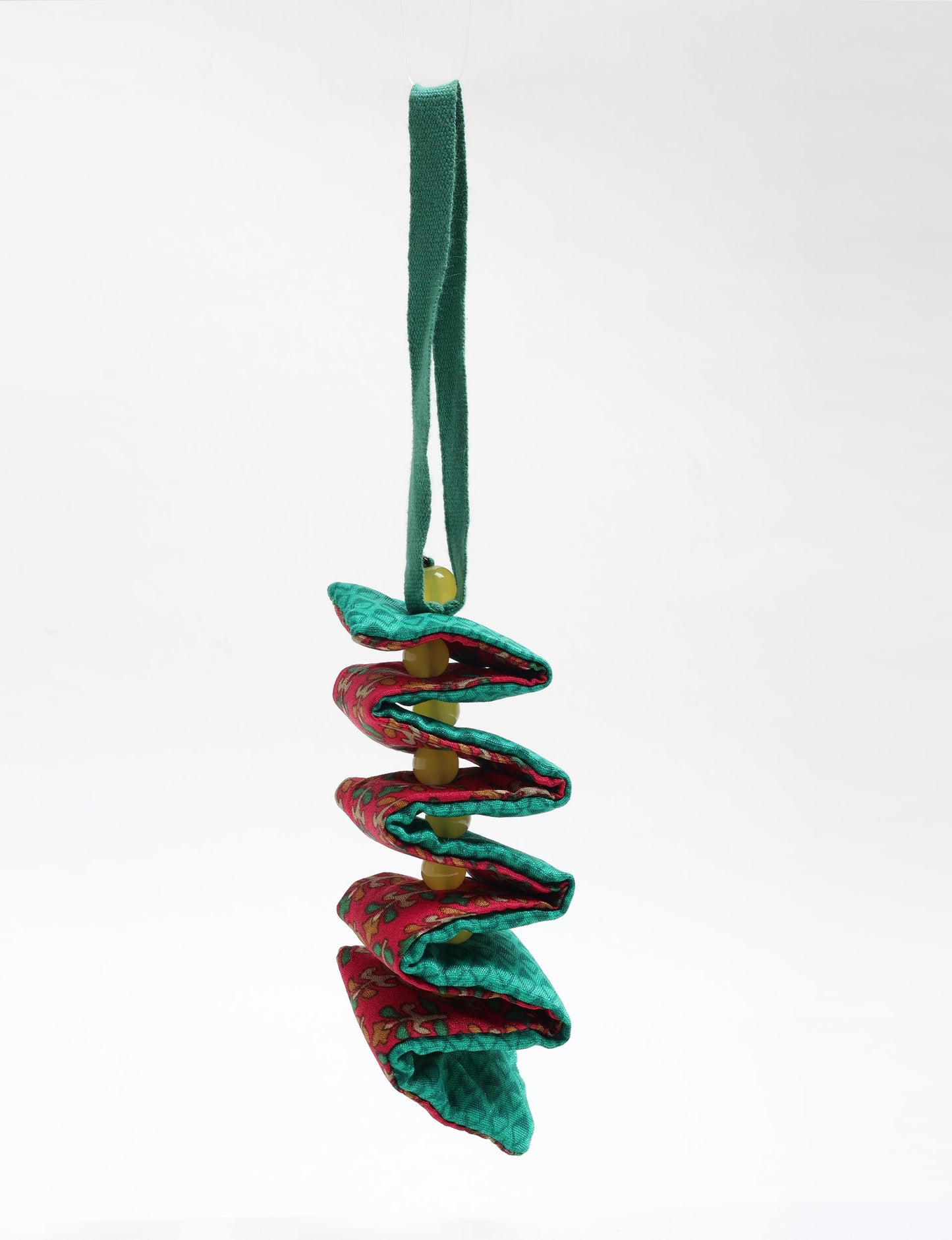 Handcrafted upcycled candy cane ornament made from recycled sari fabric and organic cotton, reflecting fair trade fashion and circular fashion principles in eco friendly, repurposed clothing craftsmanship.