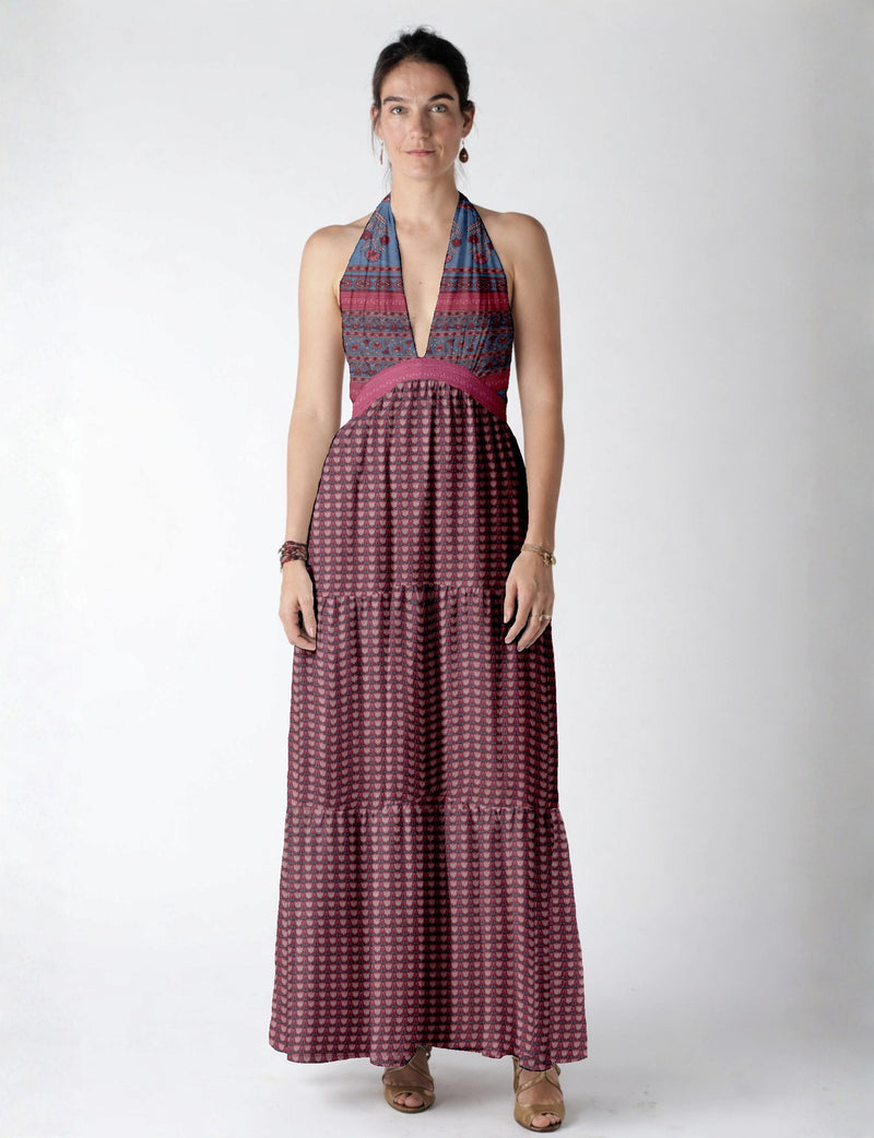 Woman wearing a sleeveless maxi tiered dress with pink and blue leaf patterns and a deep V neckline, standing front view