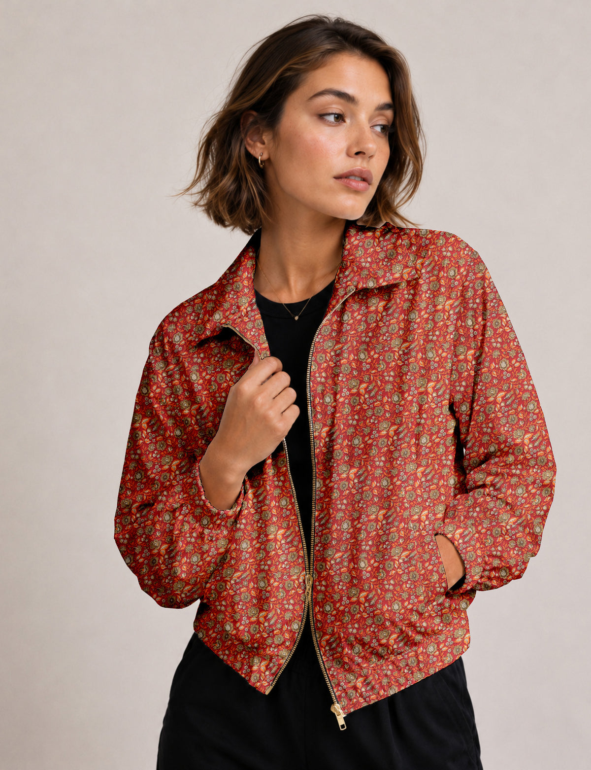 Woman wearing a yellow floral bomber jacket with front zipper, elastic cuffs, and side pockets, shown from front view