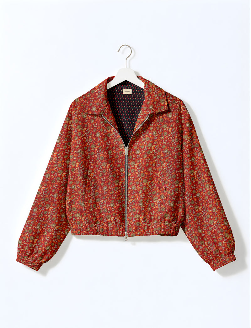 Brown floral bomber jacket with front zipper, elastic cuffs and hem, hanging on white hanger, red floral inner lining visible