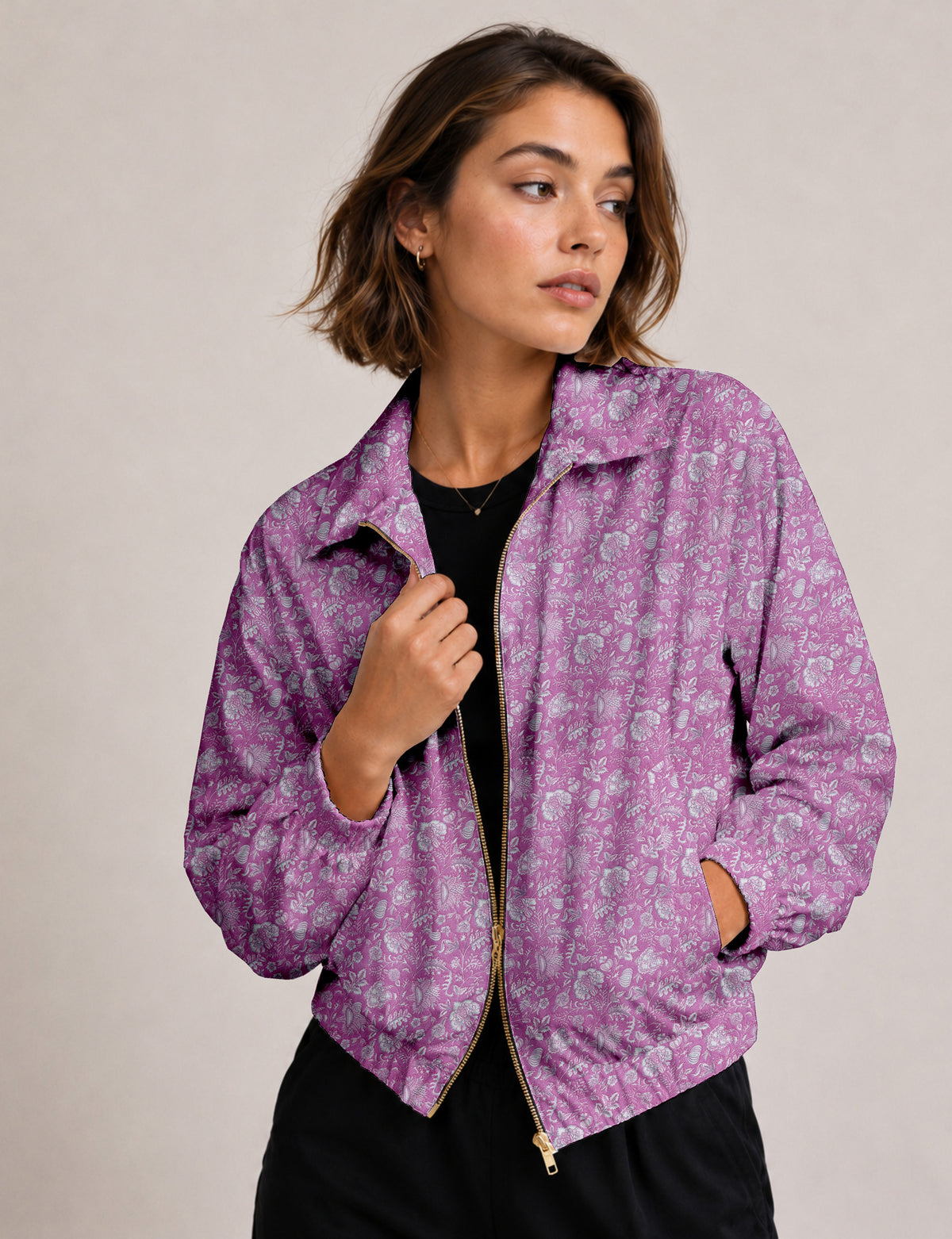 Woman wearing a yellow floral bomber jacket with front zipper, elastic cuffs, and side pockets, shown from front view
