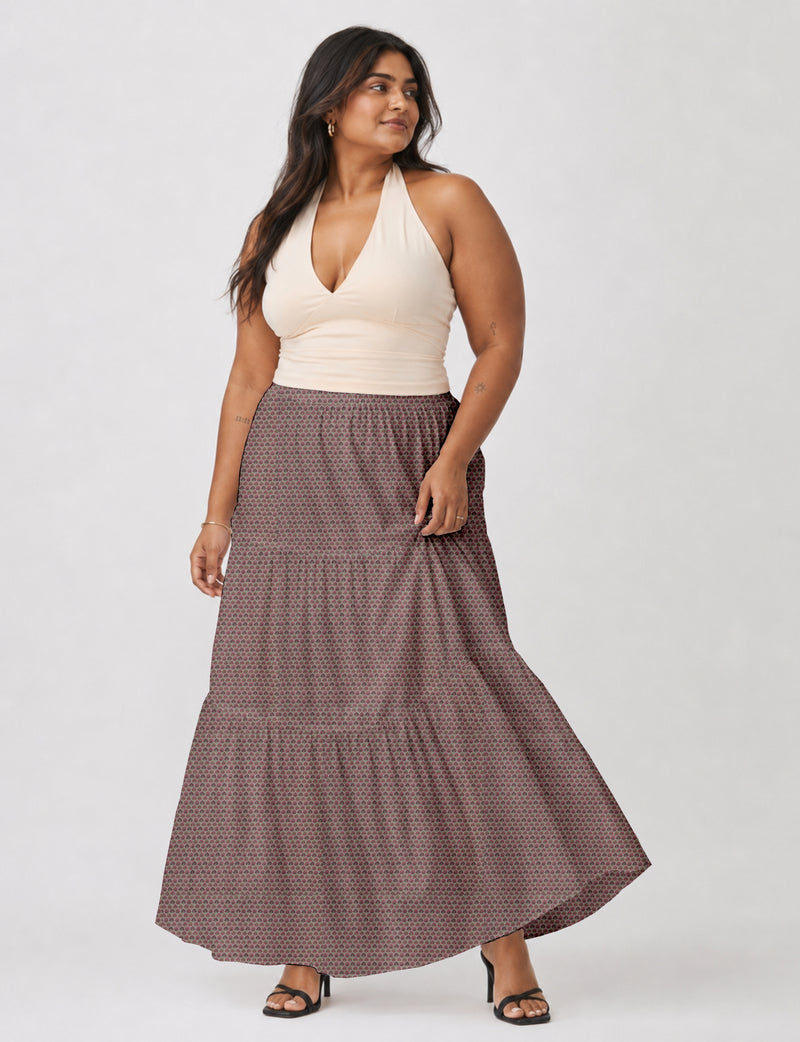 Woman wearing a pink floral midi tiered skirt with a beige halter top and black heeled sandals, front view
