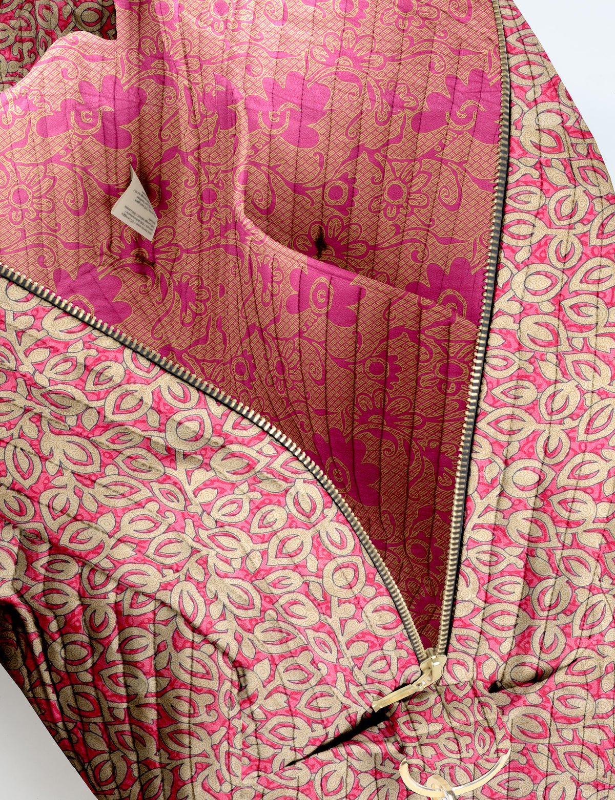 Brown quilted duffle bag with paisley pattern, front zip pocket, dual handles, and label reading "I was a sari"