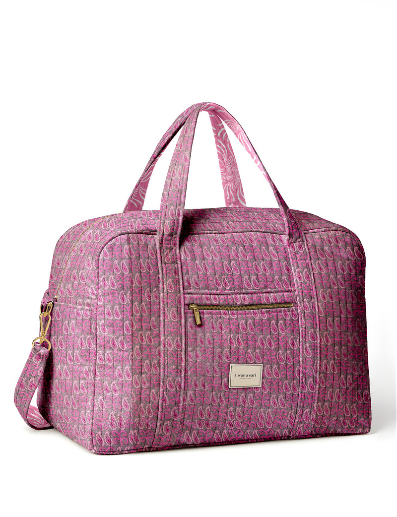 Brown quilted duffle bag with paisley pattern, front zip pocket, dual handles, and label reading "I was a sari"