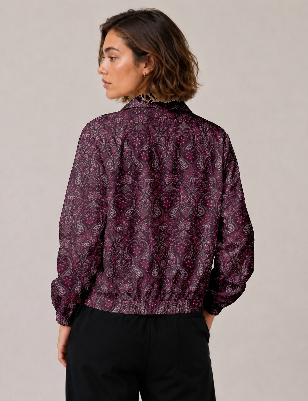 Woman wearing a yellow floral bomber jacket with front zipper, elastic cuffs, and side pockets, shown from front view