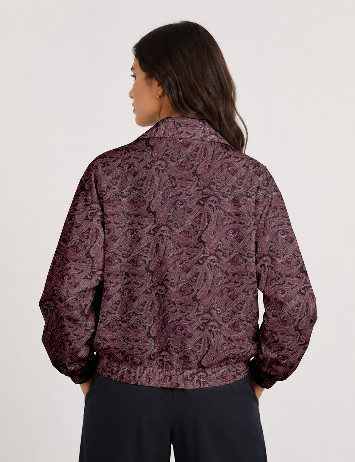 Brown floral bomber jacket with front zipper, elastic cuffs and hem, hanging on white hanger, red floral inner lining visible