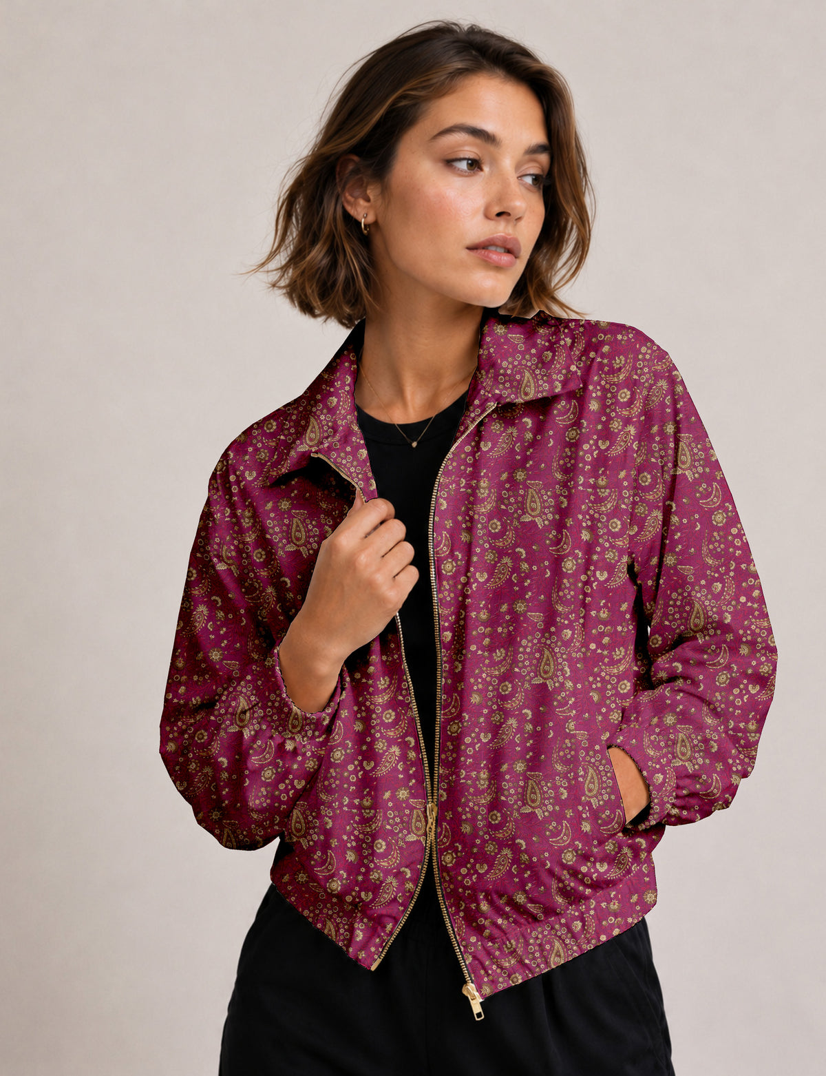 Brown floral bomber jacket with front zipper, elastic cuffs and hem, hanging on white hanger, red floral inner lining visible