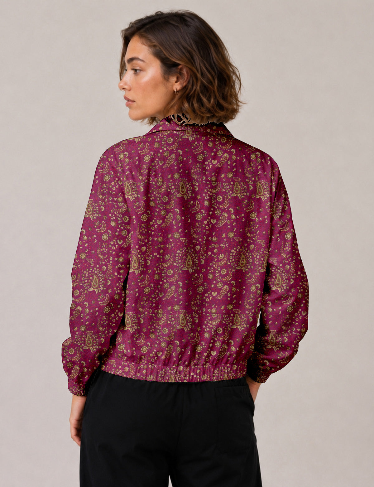 Woman wearing a yellow floral bomber jacket with front zipper, elastic cuffs, and side pockets, shown from front view