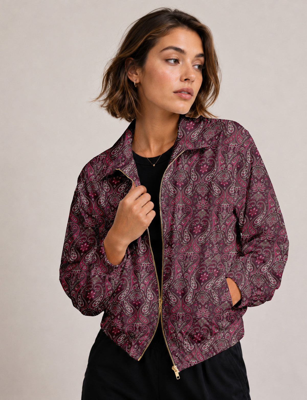 Brown floral bomber jacket with front zipper, elastic cuffs and hem, hanging on white hanger, red floral inner lining visible