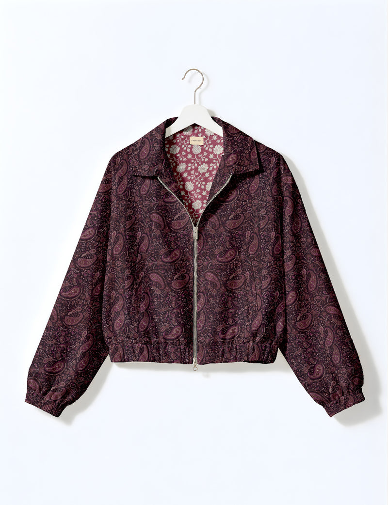 Brown floral bomber jacket with front zipper, elastic cuffs and hem, hanging on white hanger, red floral inner lining visible
