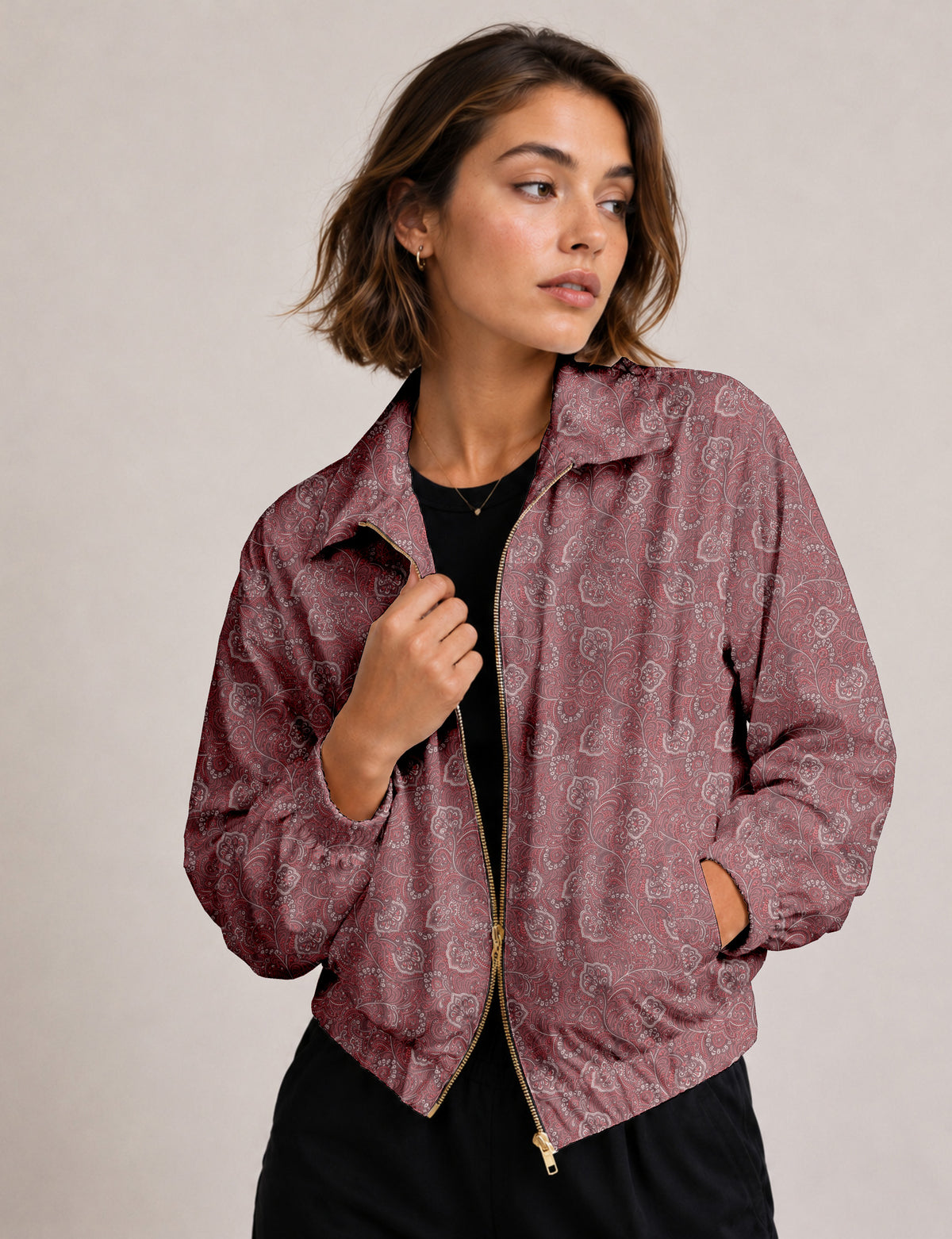Woman wearing a yellow floral bomber jacket with front zipper, elastic cuffs, and side pockets, shown from front view