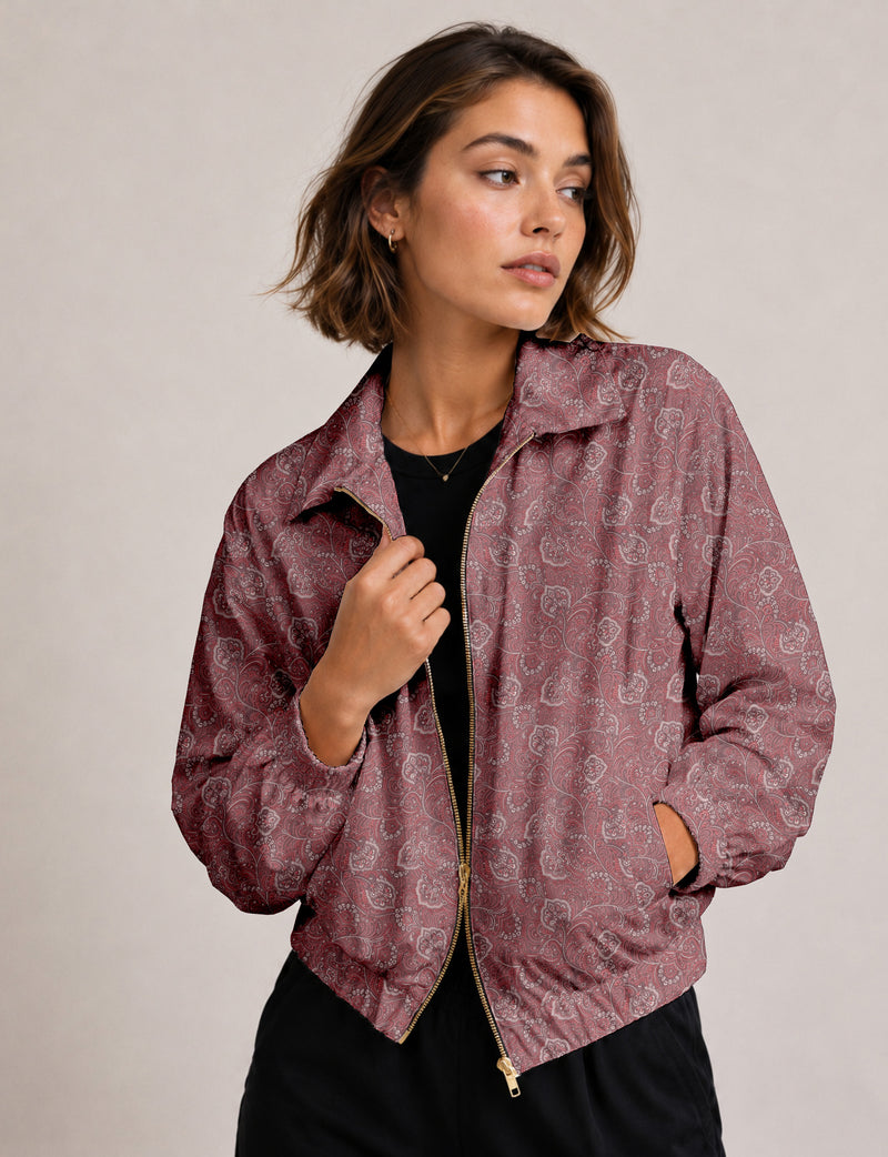 Woman wearing a yellow floral bomber jacket with front zipper, elastic cuffs, and side pockets, shown from front view