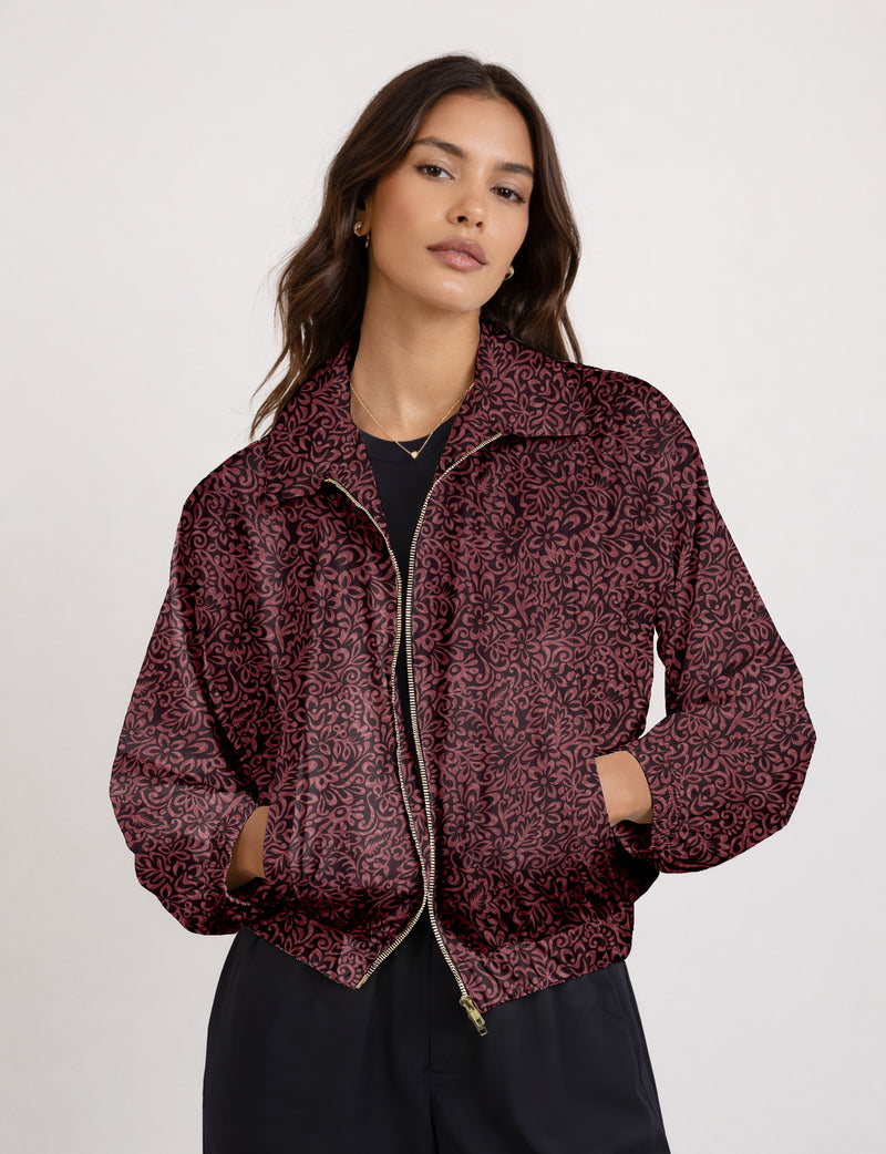 Woman wearing a yellow floral bomber jacket with front zipper, elastic cuffs, and side pockets, shown from front view