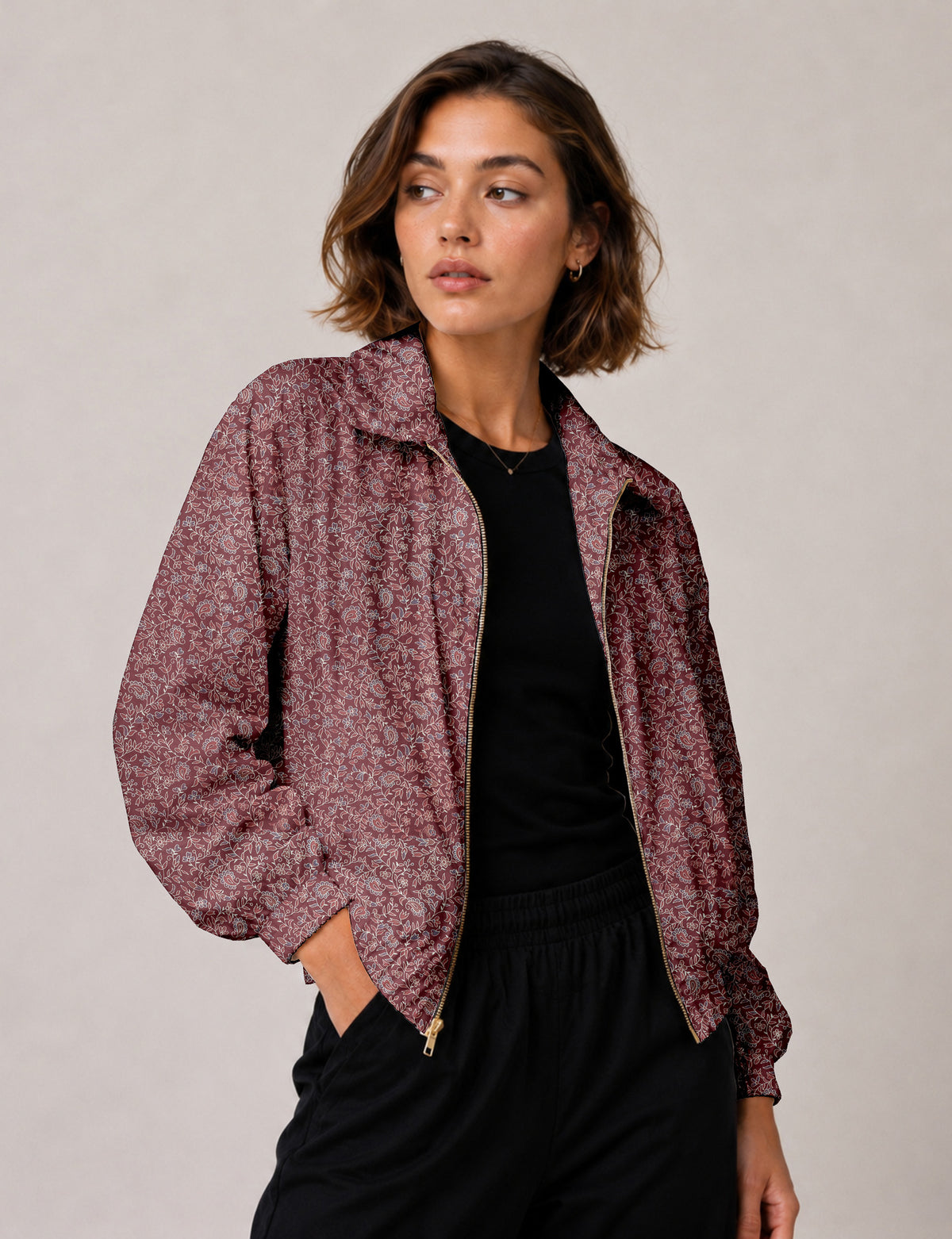 Woman wearing a yellow floral bomber jacket with front zipper, elastic cuffs, and side pockets, shown from front view