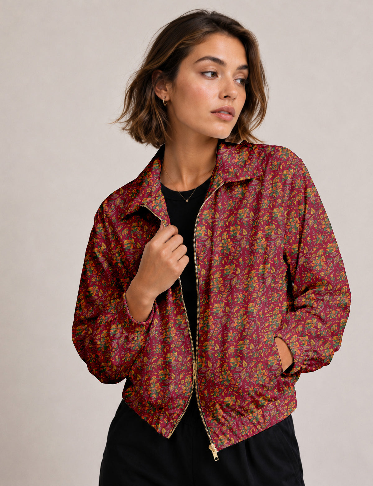 Woman wearing a yellow floral bomber jacket with front zipper, elastic cuffs, and side pockets, shown from front view